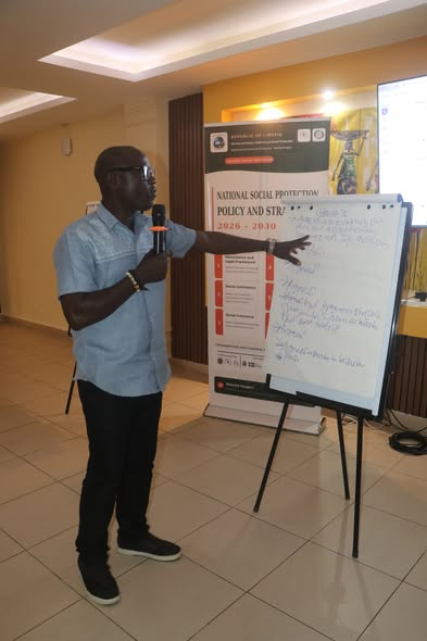 Presenter discusses social protection policy priorities beside a whiteboard